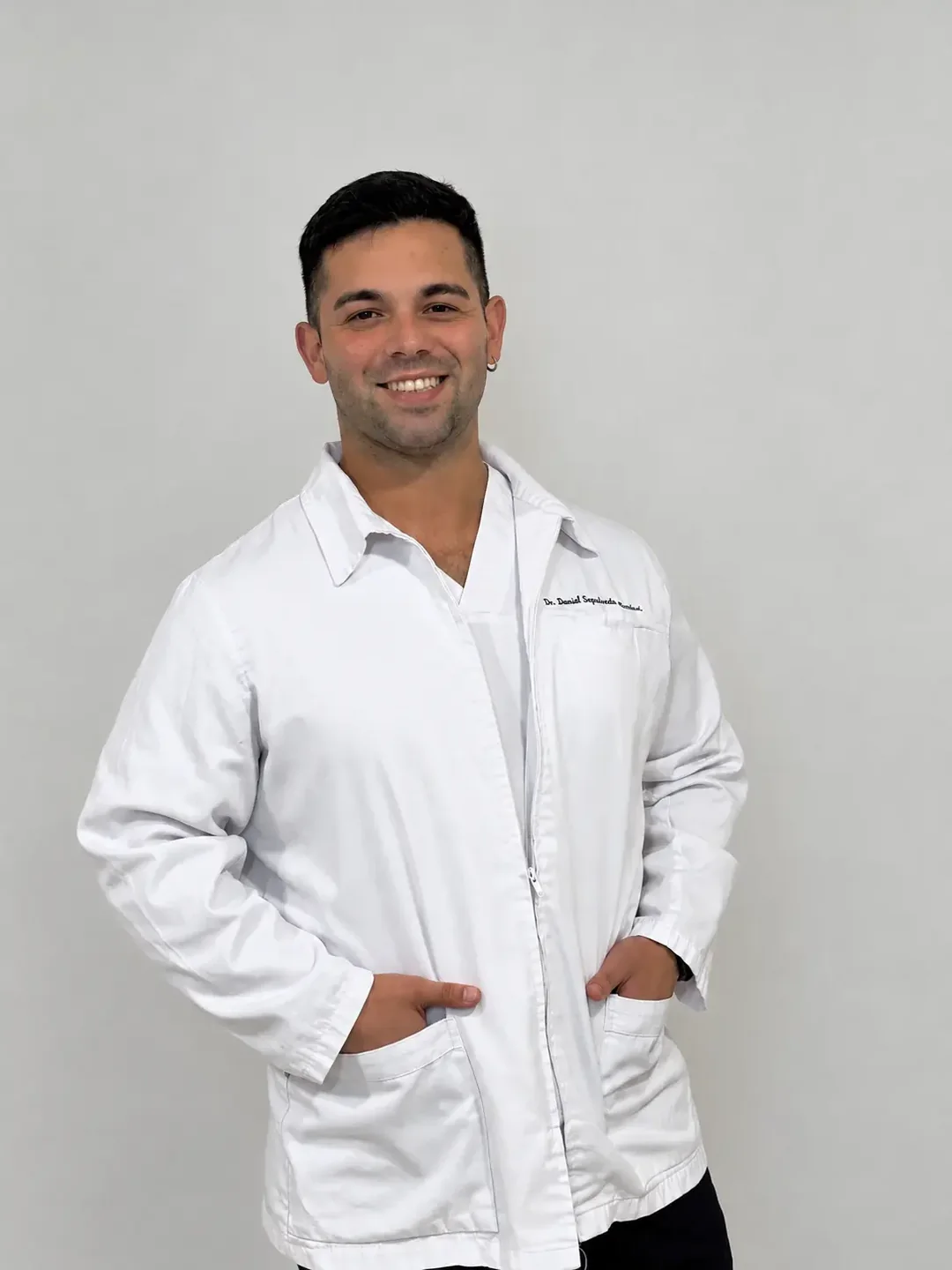 Dr. Daniel Sepúlveda Barbieri, Cirujano Dentista. El Dr. Daniel Sepúlveda Barbieri sonríe con su bata clínica blanca